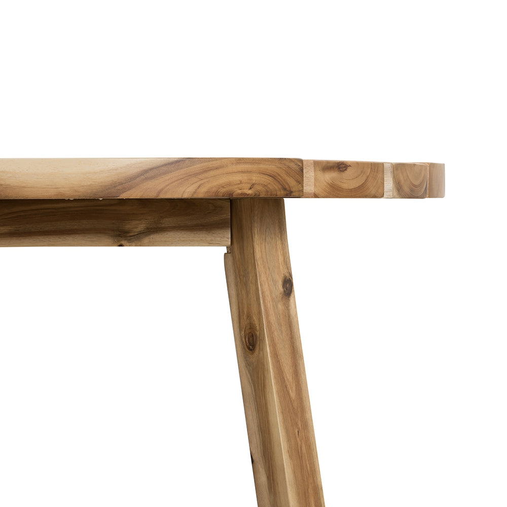 Closeup of a rustic acacia wood dining table with visible grain and joinery