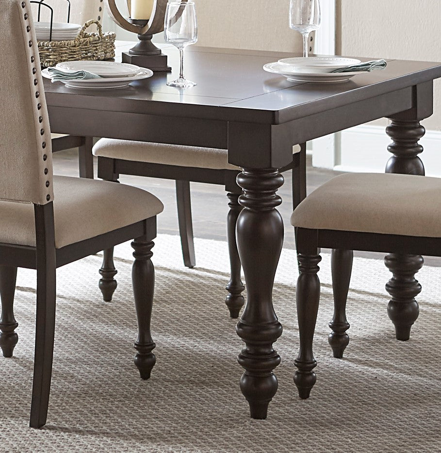 Dark brown wooden dining table with turned legs and upholstered chairs