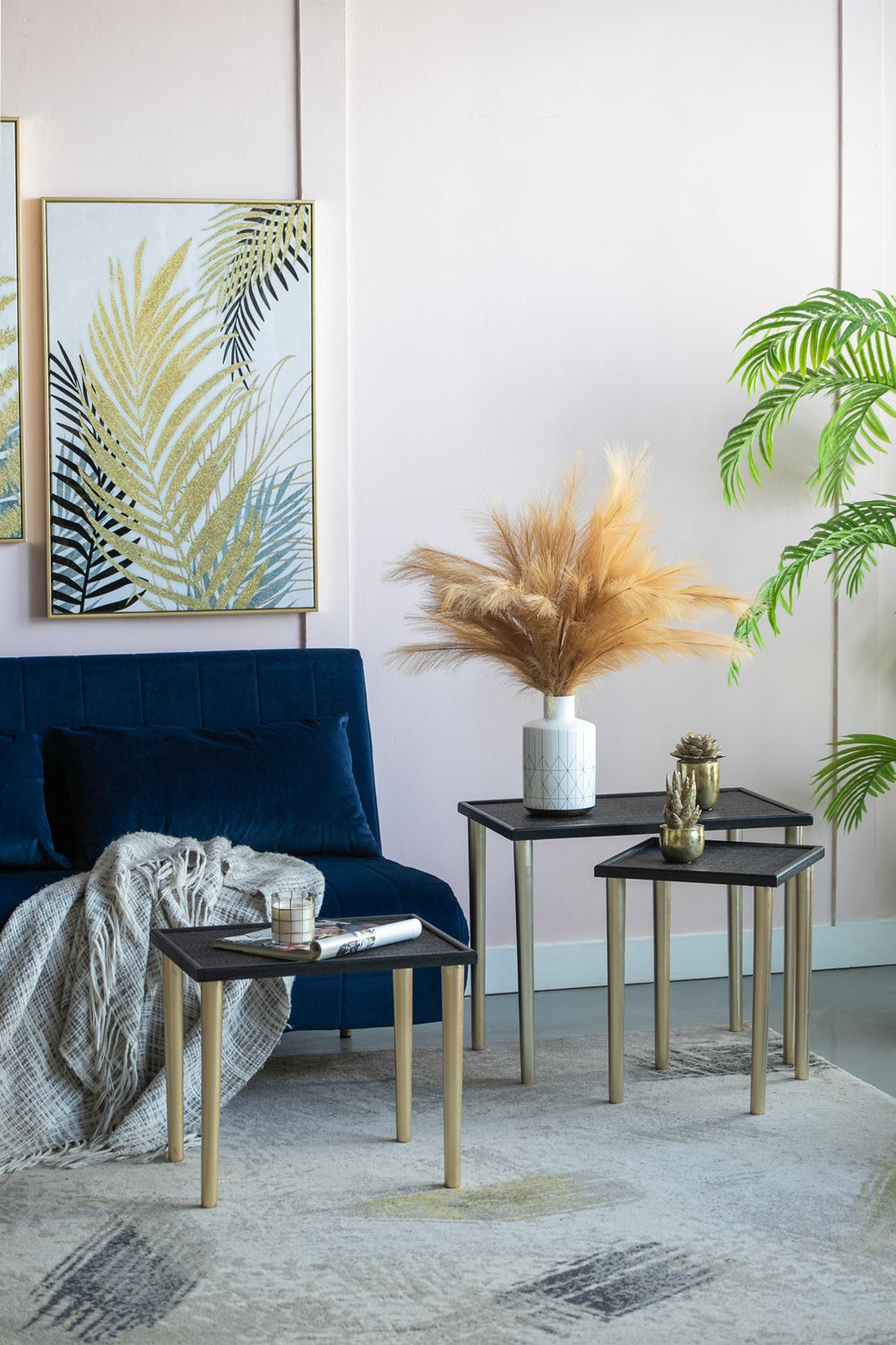 Gold framed botanical art with glittering palm leaves on a pink wall