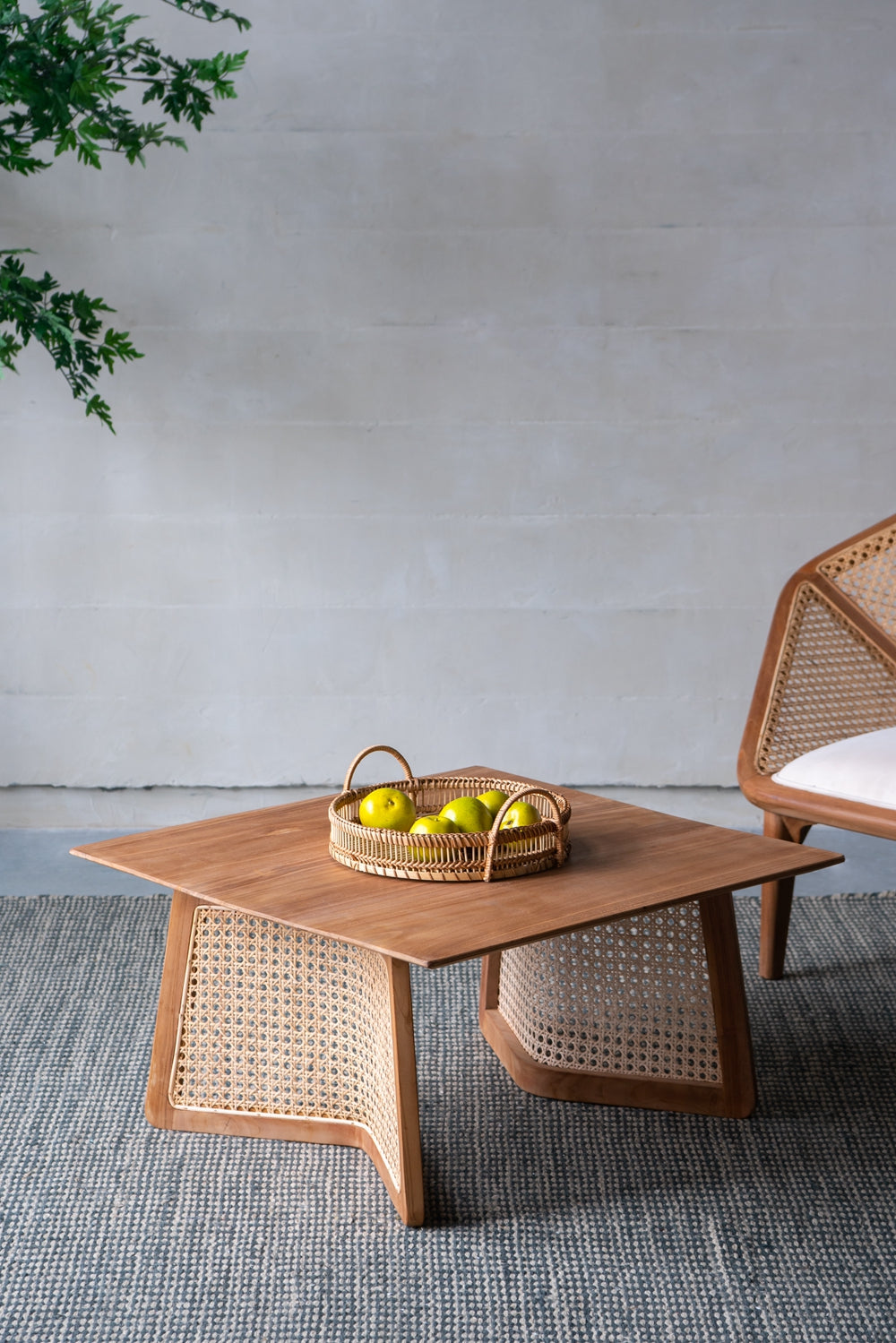 Wooden coffee table with woven cane accents and a fruit basket