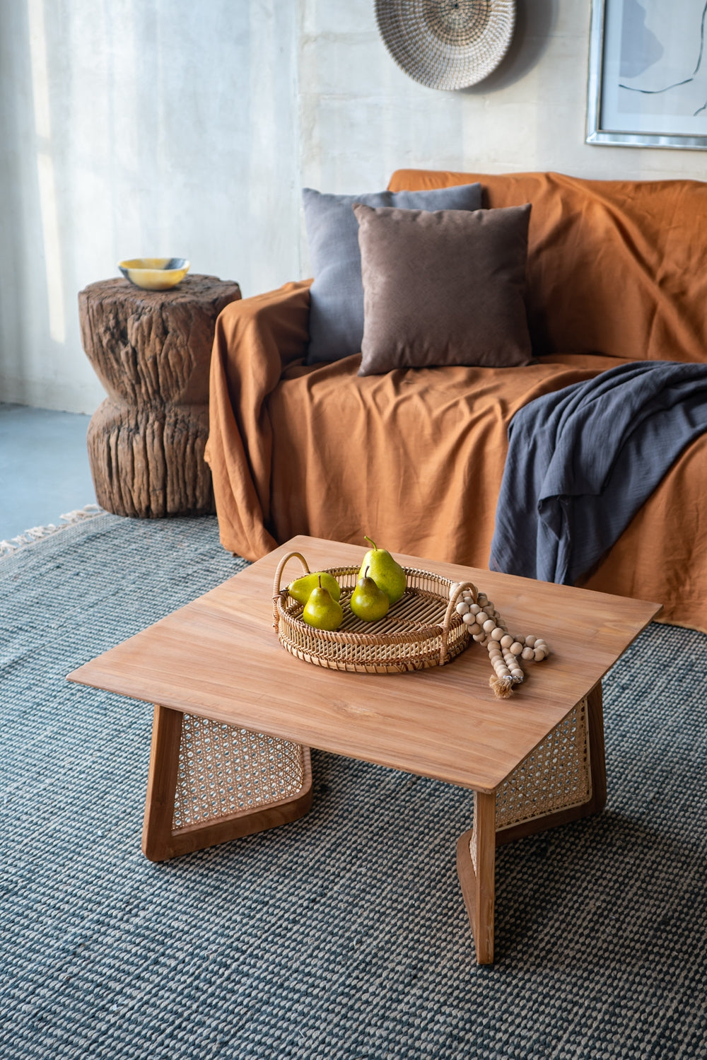 Natural wood coffee table with woven cane accents and pears