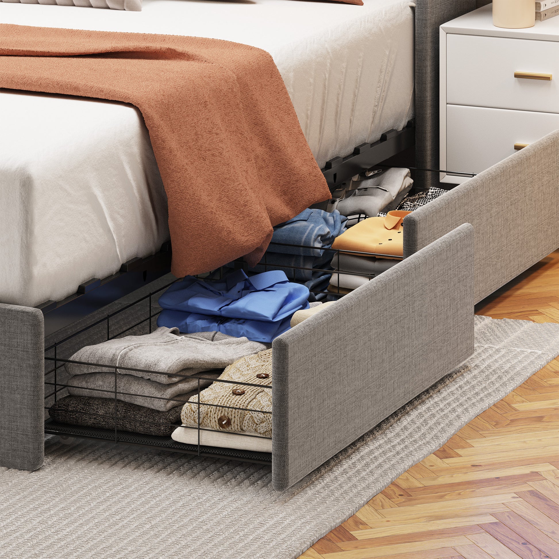 Grey upholstered bed frame with open storage drawers full of folded clothes