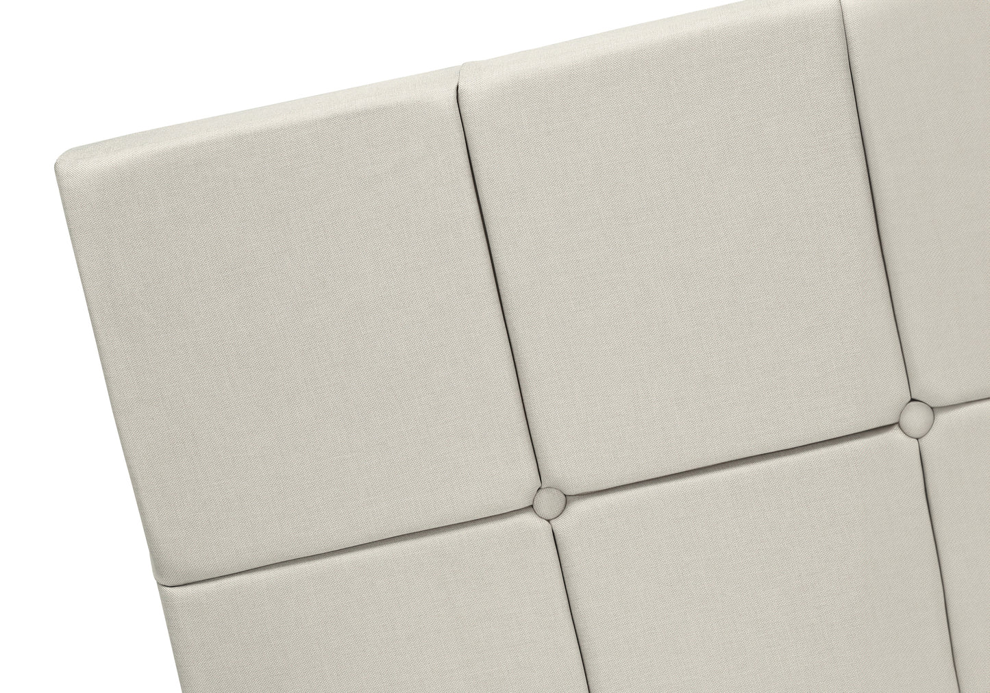 Upholstered beige headboard detail with square tufting