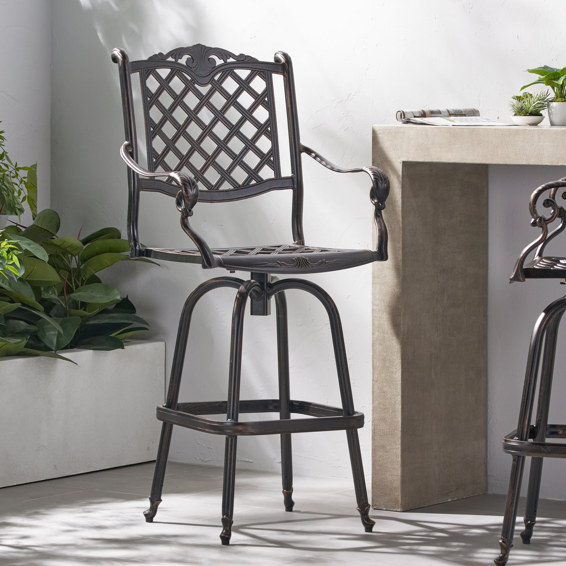 Ornate bronze swivel bar stool with lattice back and scrolled arms