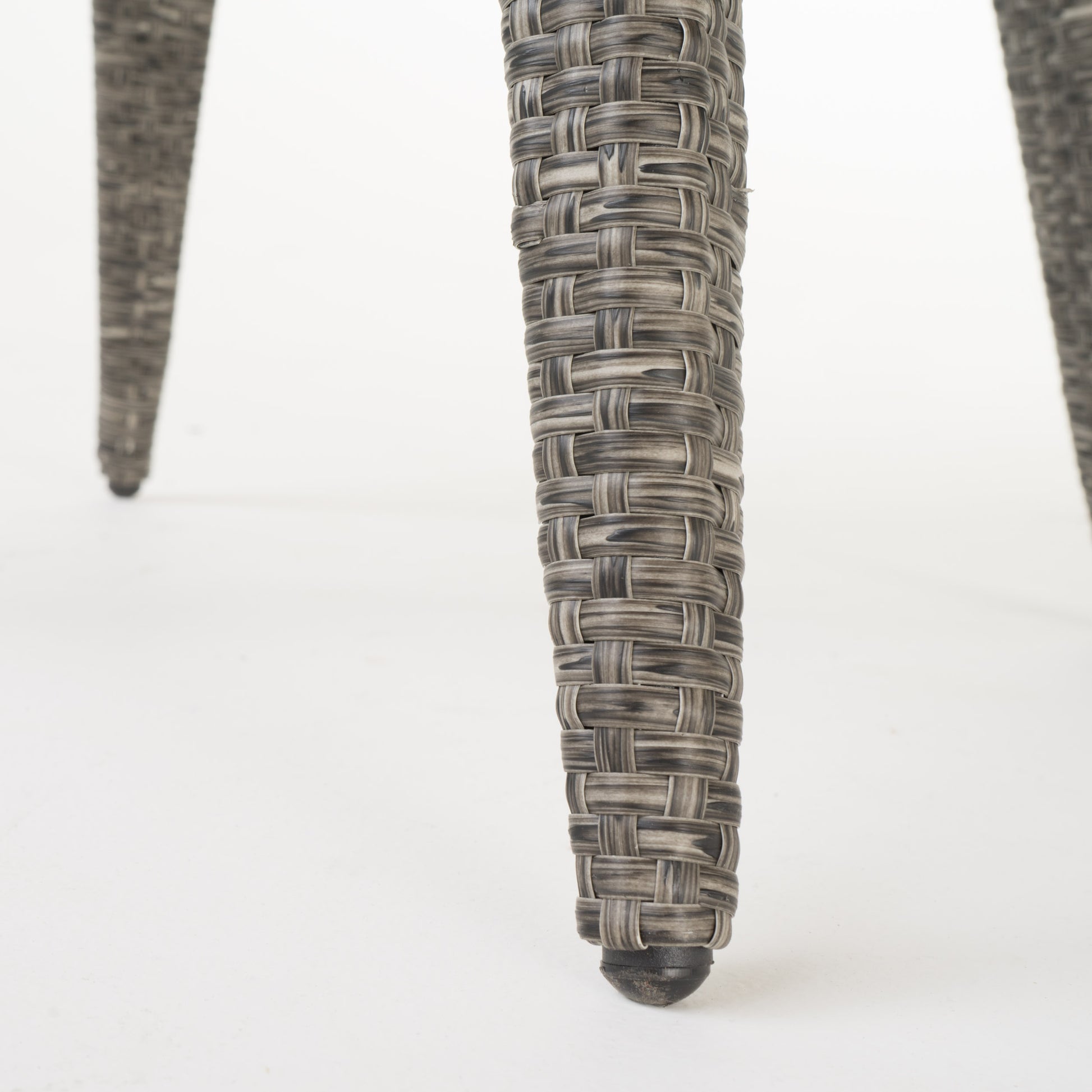 Woven rattan chair leg in grey tones