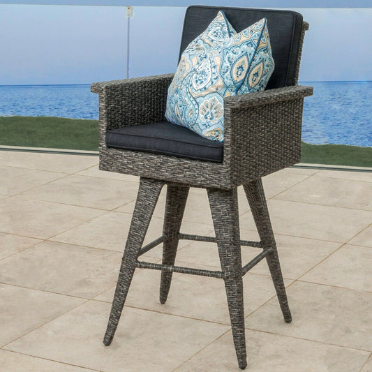 Gray wicker swivel bar stool with navy cushion and paisley pillow