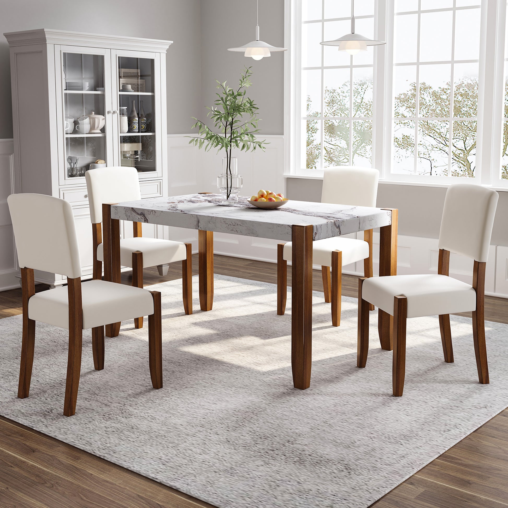 Marble top dining table with four cream upholstered chairs and dark wood legs
