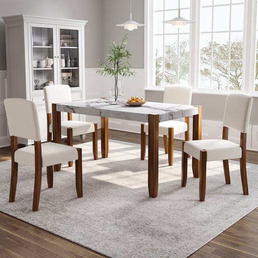Marble top dining table with four cream upholstered chairs and dark wood legs