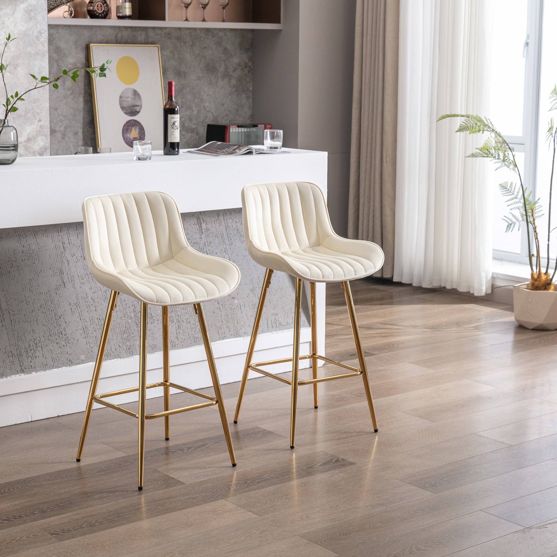 Cream upholstered bar stool with gold metal legs and channeled design