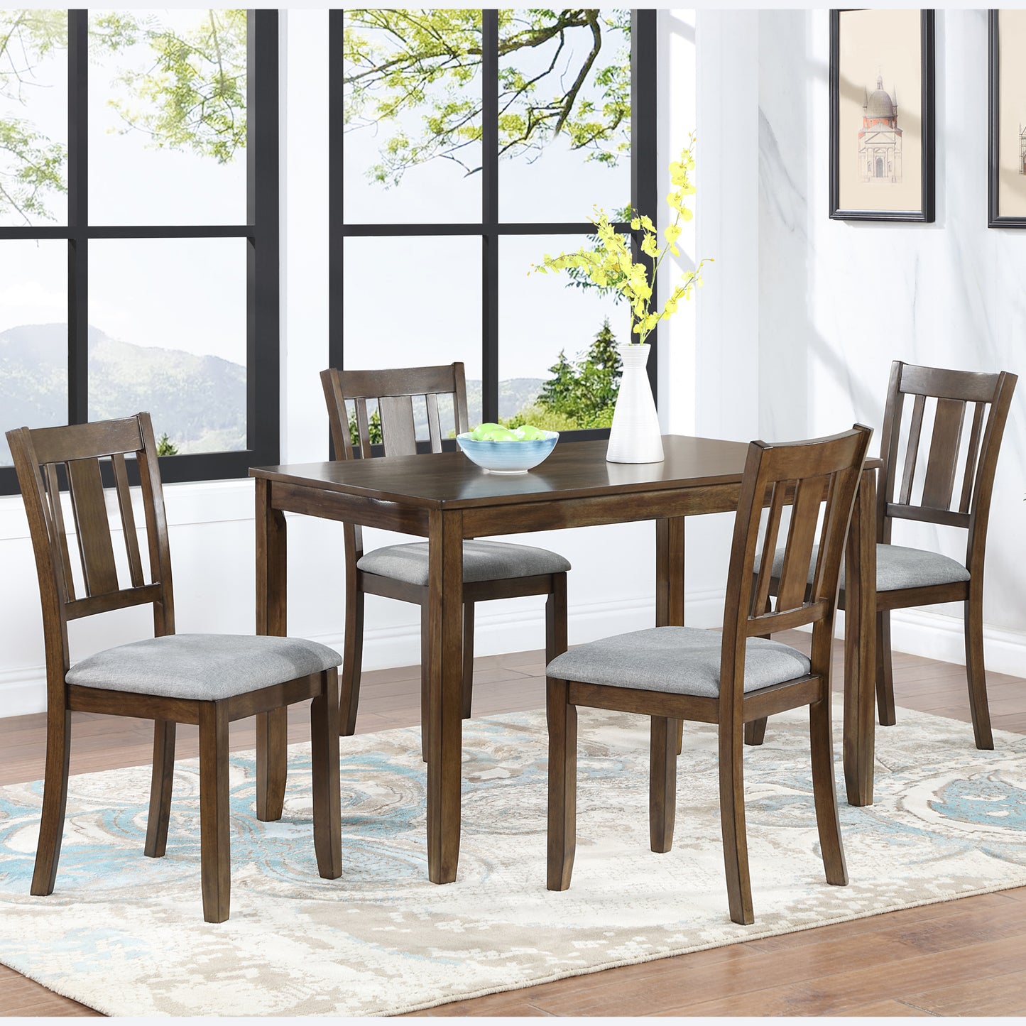 Wooden dining table with four grey upholstered chairs in a bright room