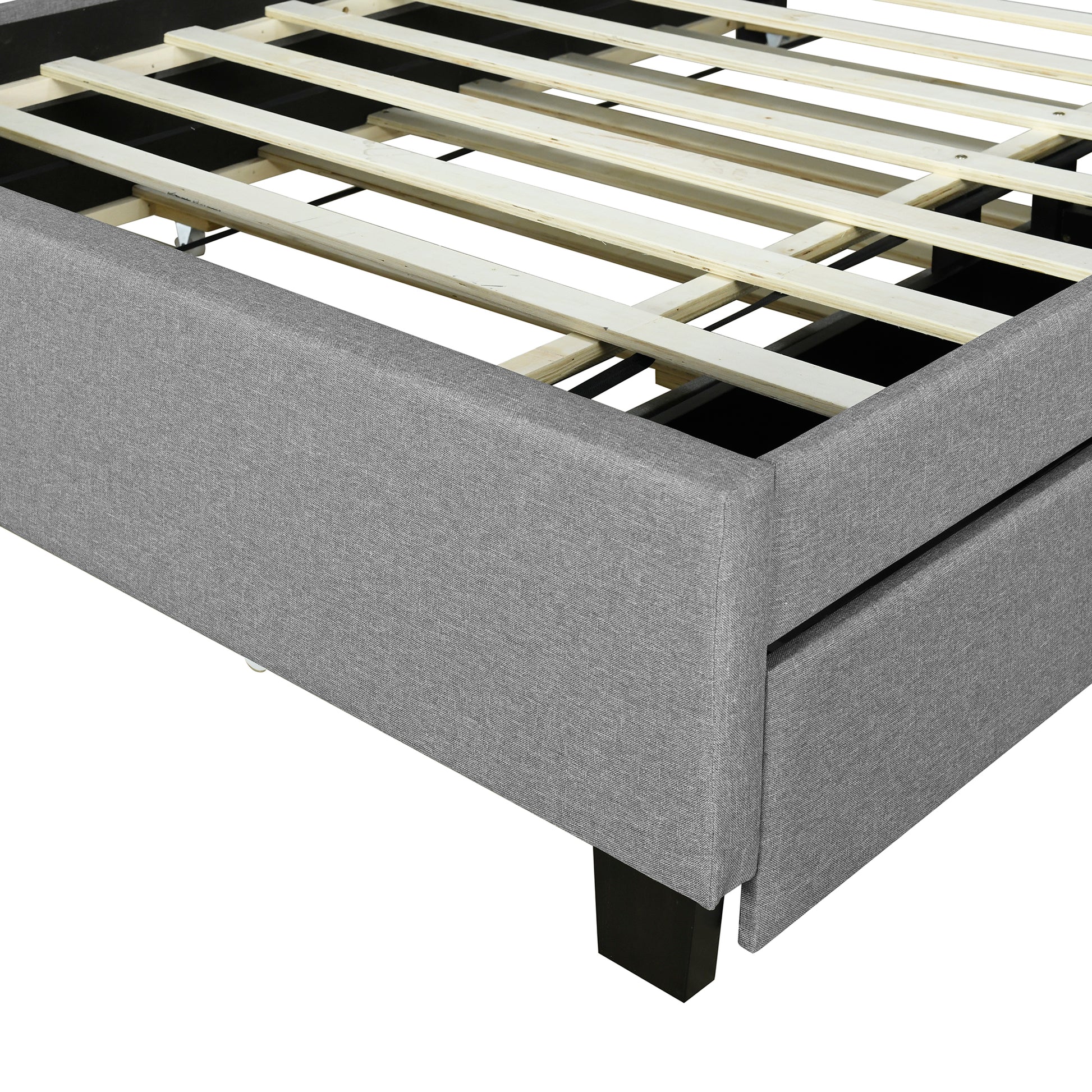 Gray upholstered bed frame detail with wooden slat support