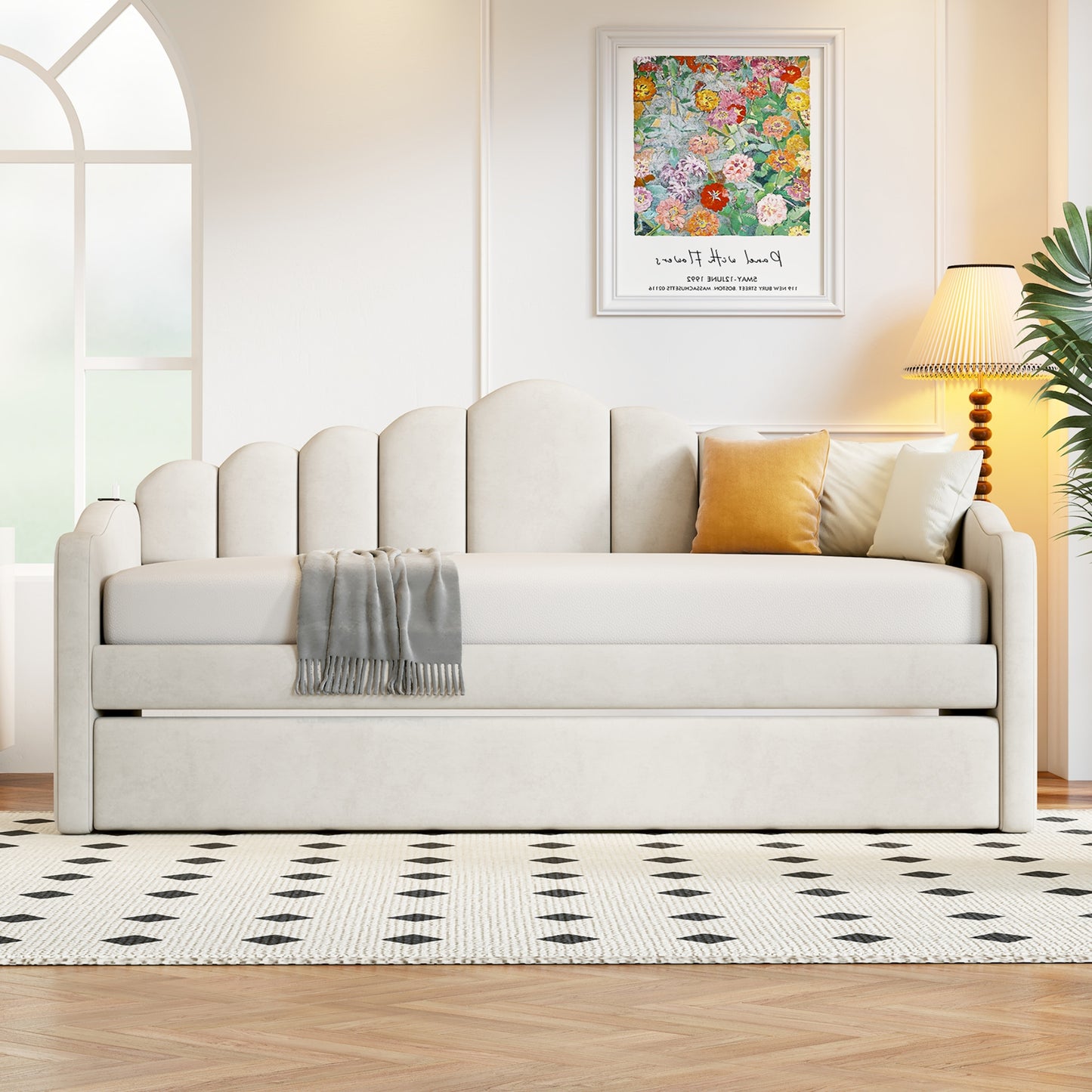 Cream upholstered daybed with scalloped back and pullout trundle