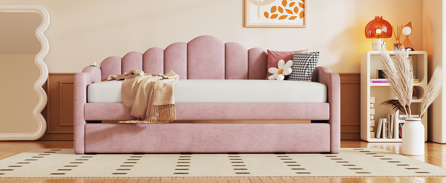 Pink velvet daybed with scalloped headboard and pullout trundle for guest room