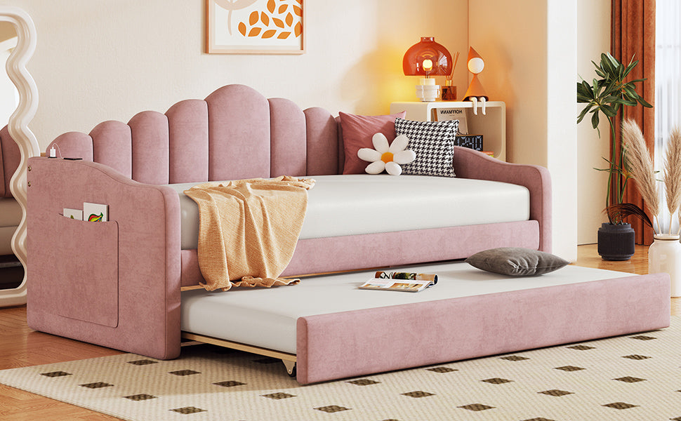 Pink upholstered daybed with scalloped back and pullout trundle