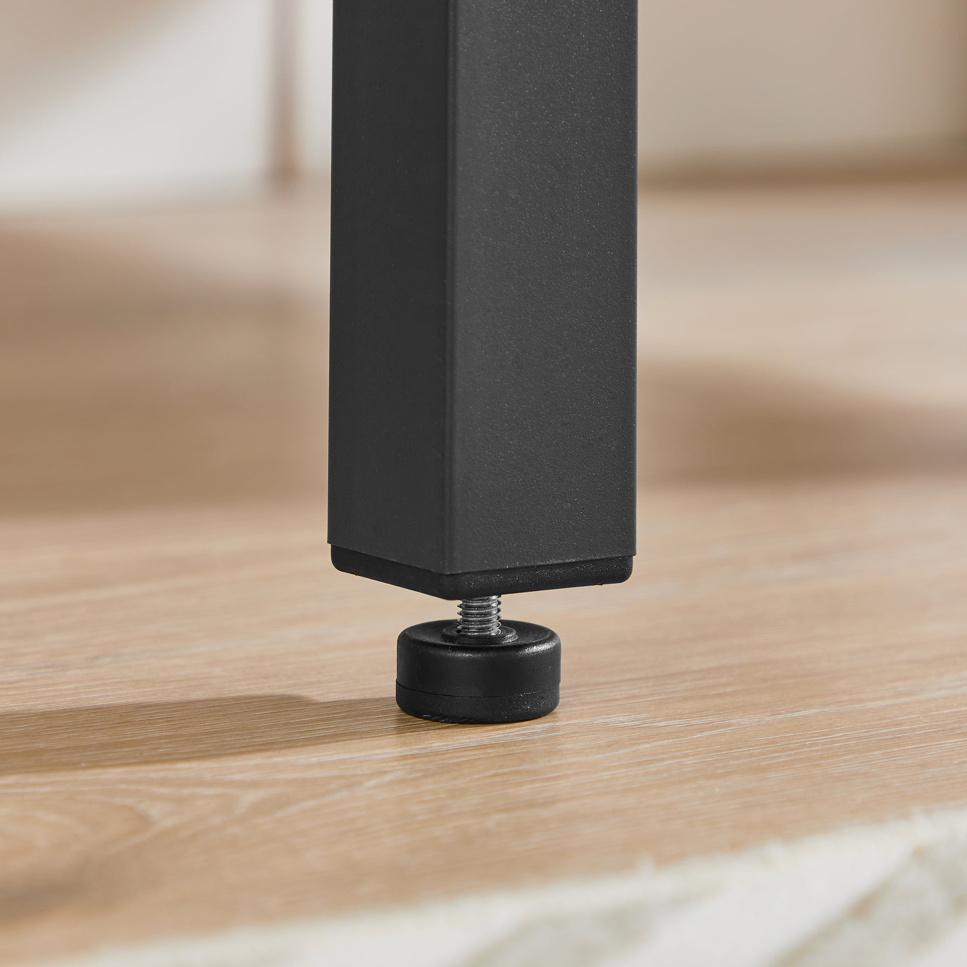 Black metal table leg with adjustable leveling foot