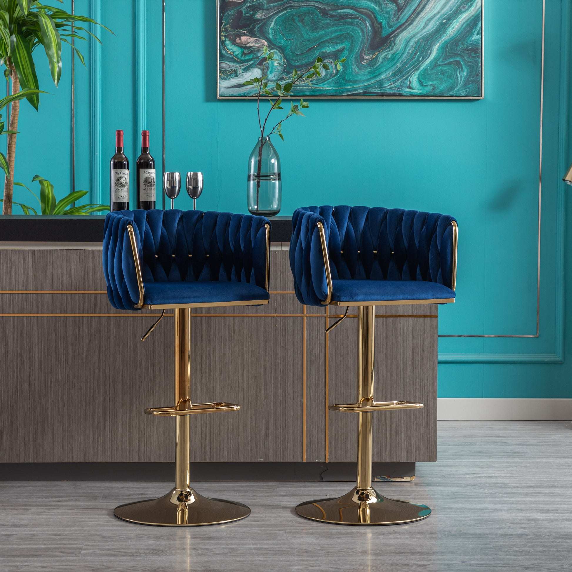 Two plush navy velvet bar stools with gold accents