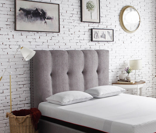 Tufted grey fabric headboard with silver nailhead trim suitable for a queen size bed