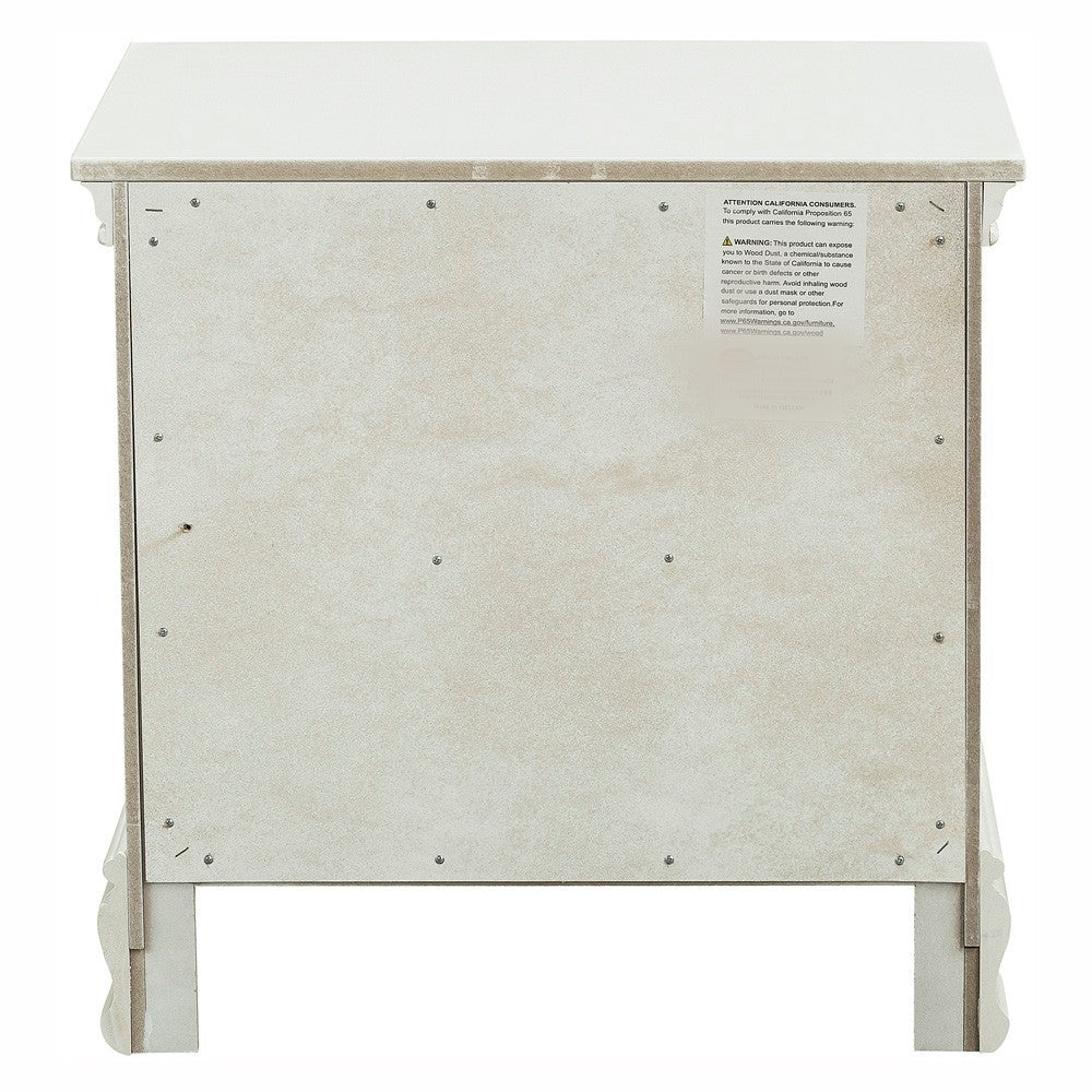 Back view of white particleboard nightstand with ornate legs