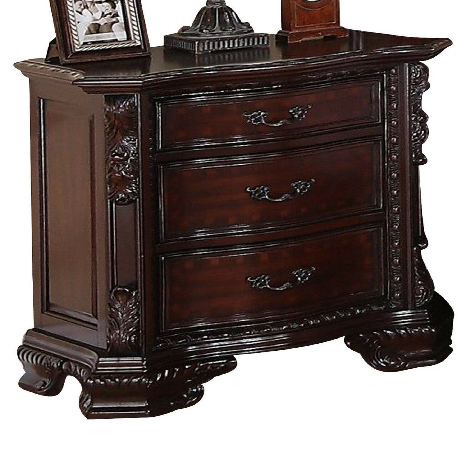 Dark cherry wood nightstand with three drawers and ornate carving