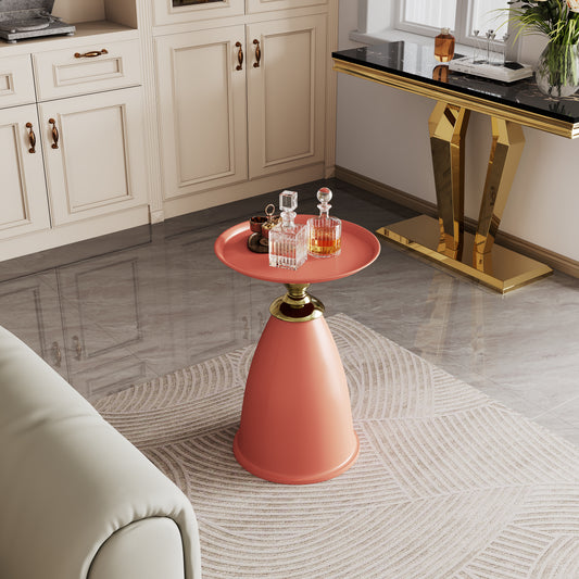 Coral accent table with gold base and decorative items