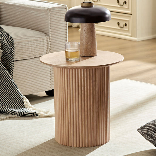 Round fluted oak side table with a textured lamp and drink