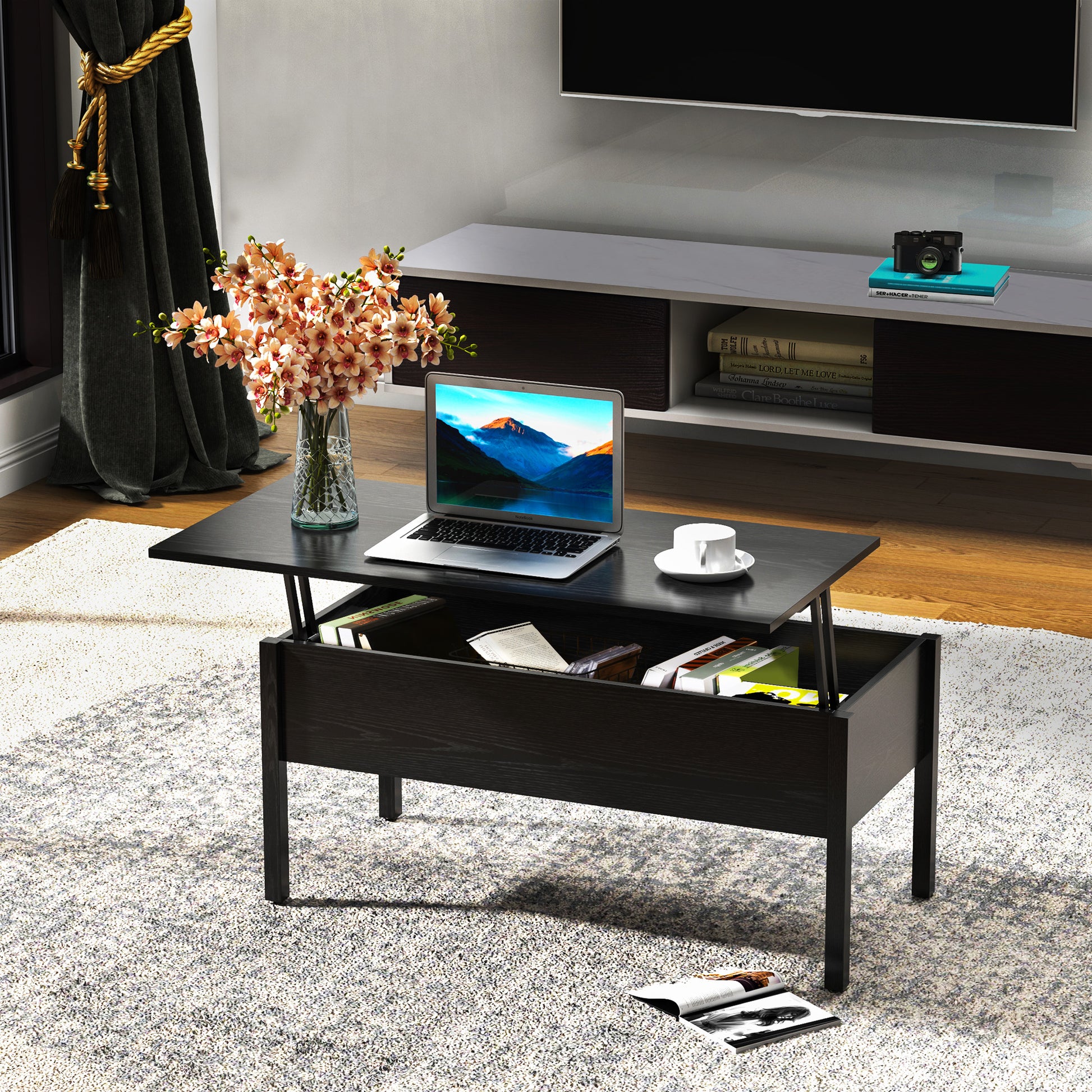 Dark wood lifttop coffee table with open storage holding a laptop and books