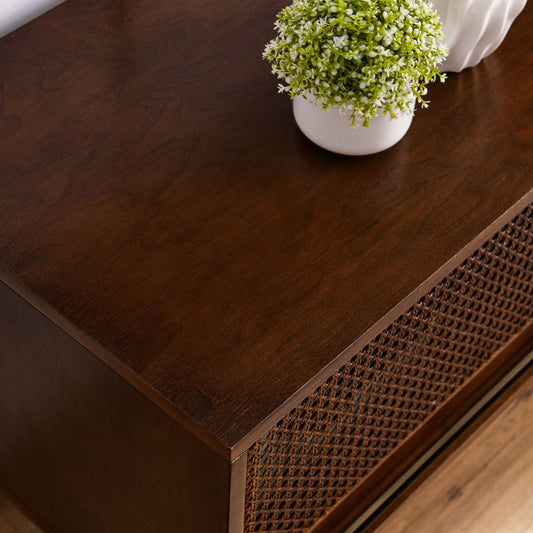 Dark wood media console with woven cane door detail