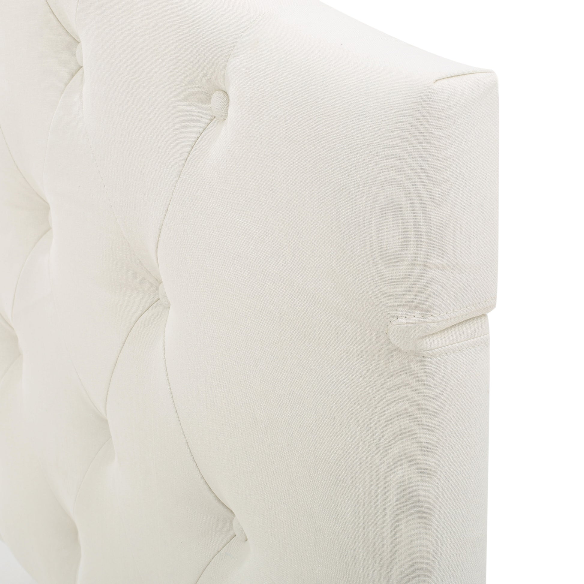 Cream linen tufted headboard detail with button tufting