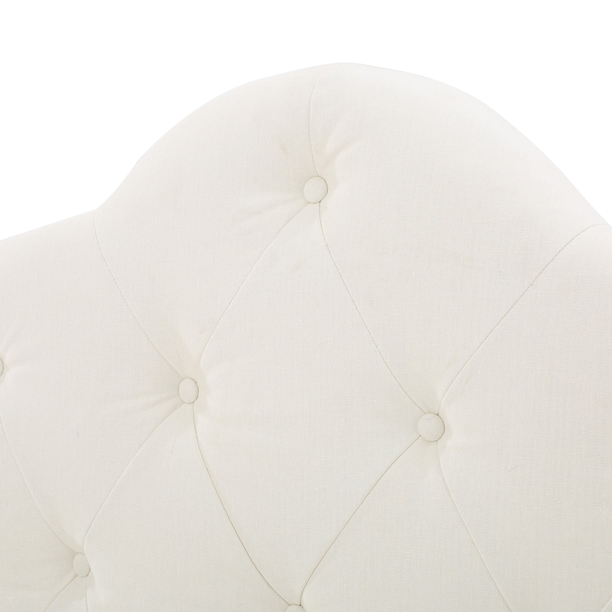 Cream tufted linen upholstery on a headboard with button accents