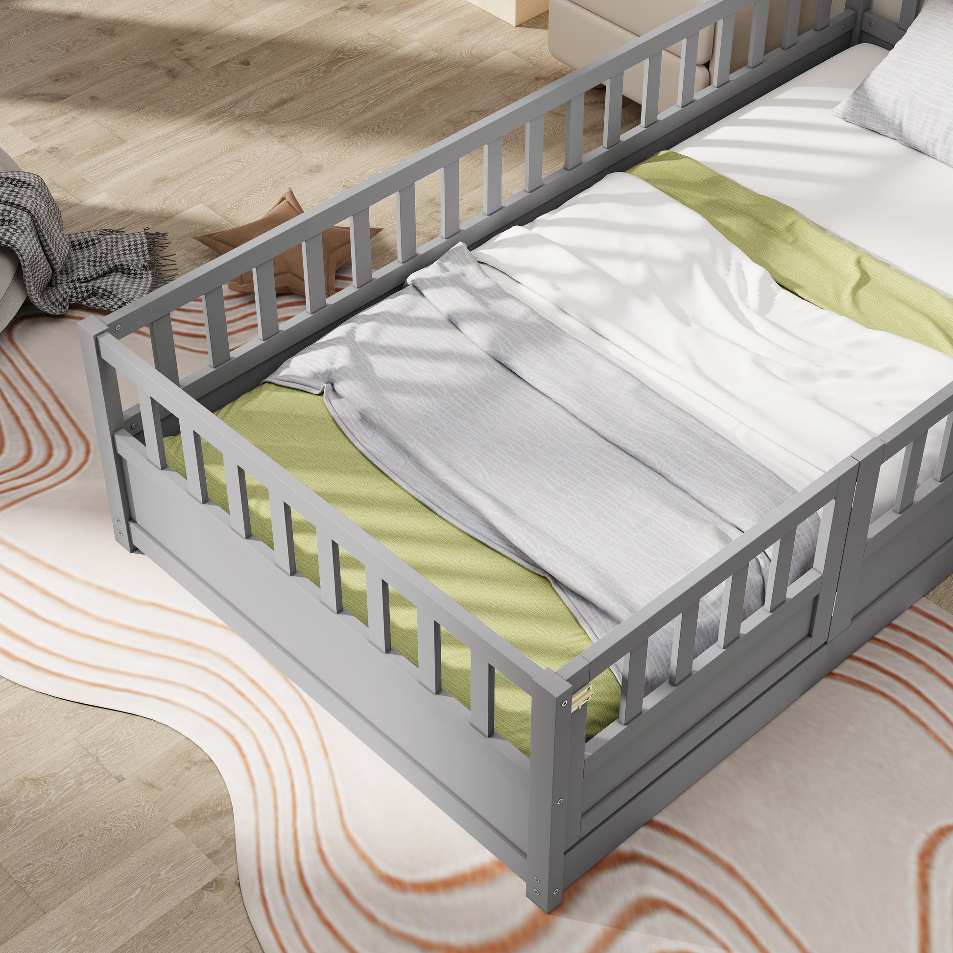 Grey wooden toddler bed with protective rails and white bedding
