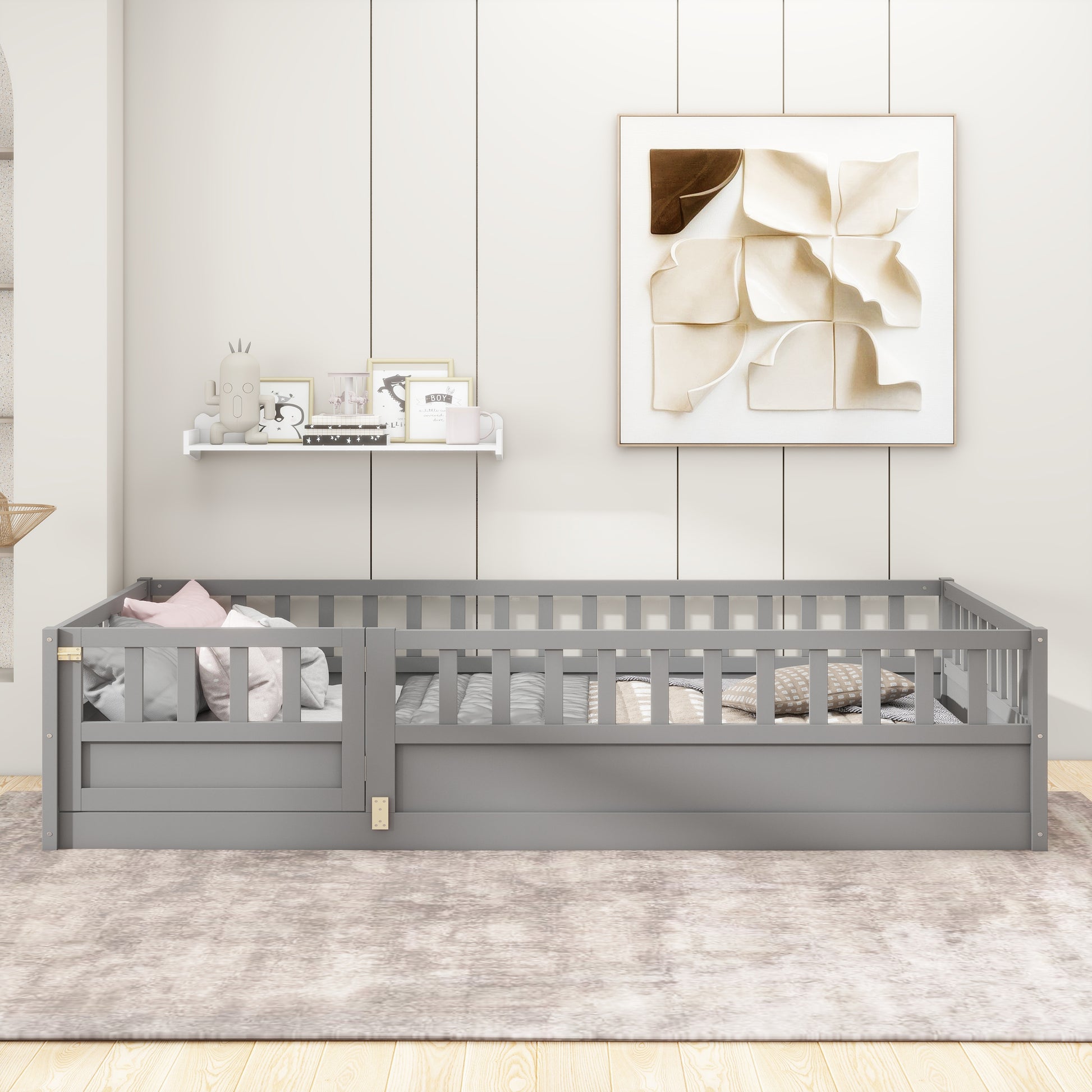 Gray wooden toddler bed frame with safety rails and pillows