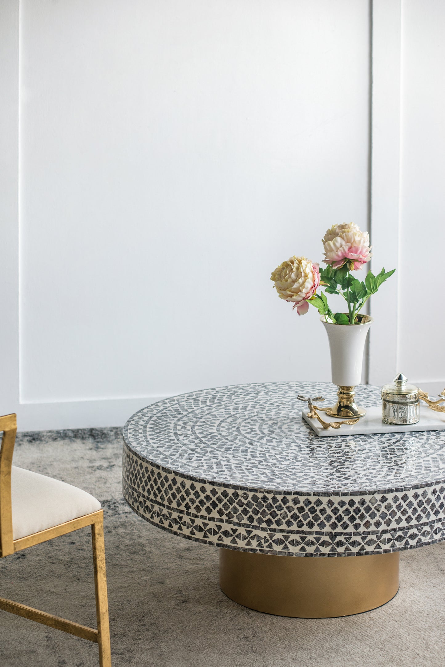 Round mosaic coffee table with intricate black and white geometric pattern and gold base