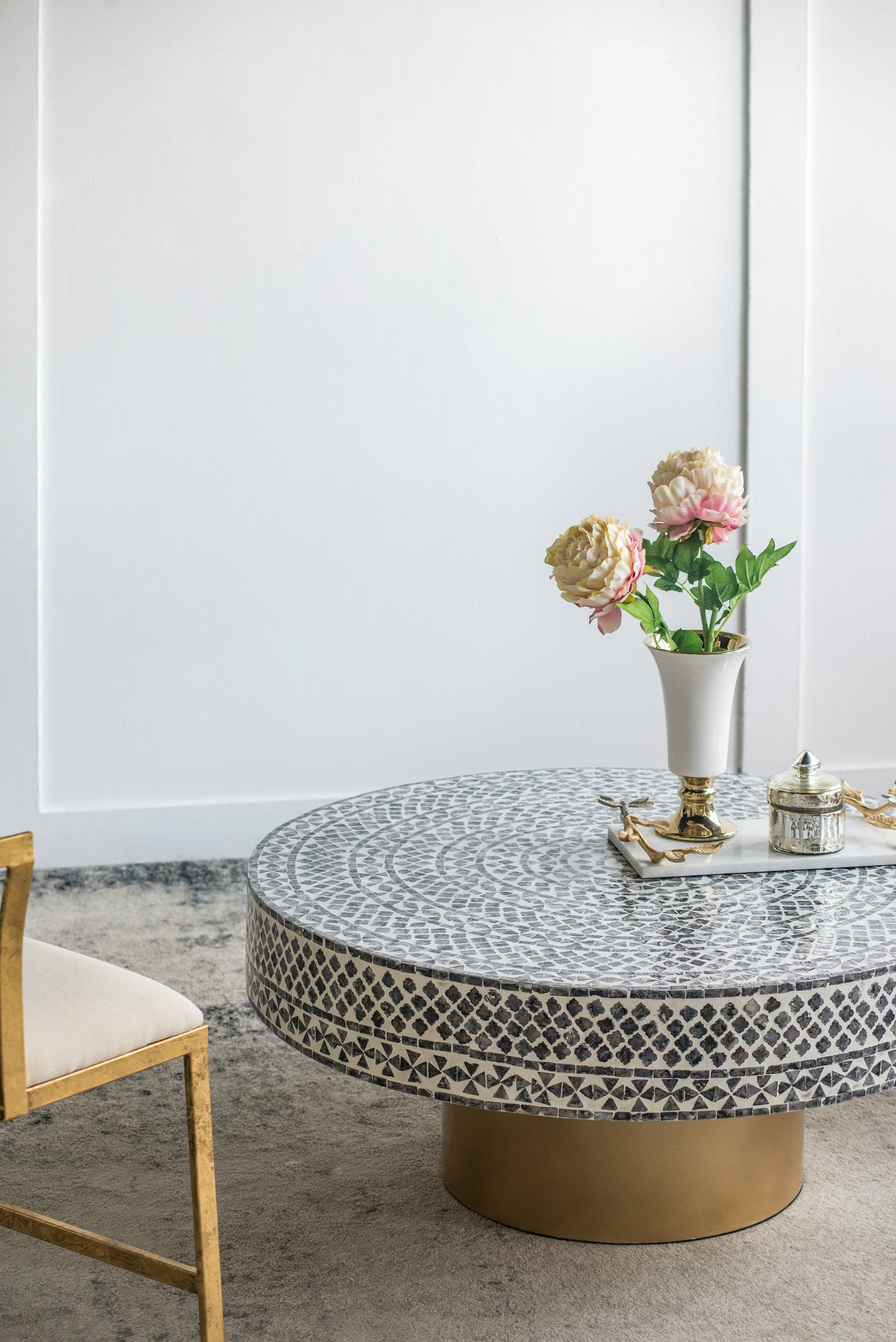 Round mosaic coffee table with intricate black and white geometric pattern and gold base