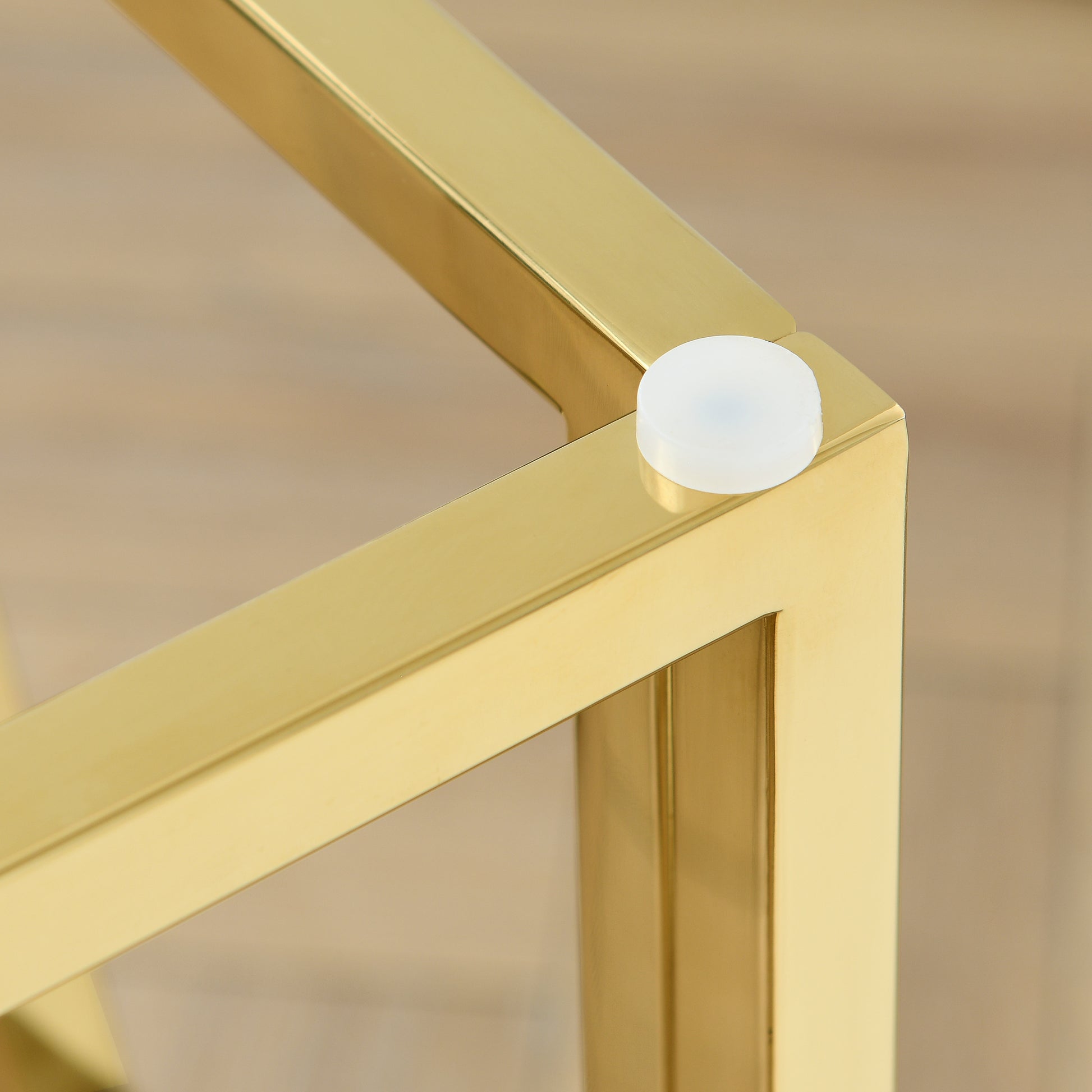 Closeup of polished brass table leg corner with white floor protector