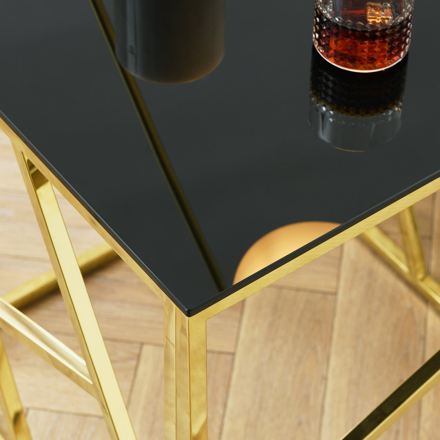 Elegant black glass coffee table with polished gold geometric base