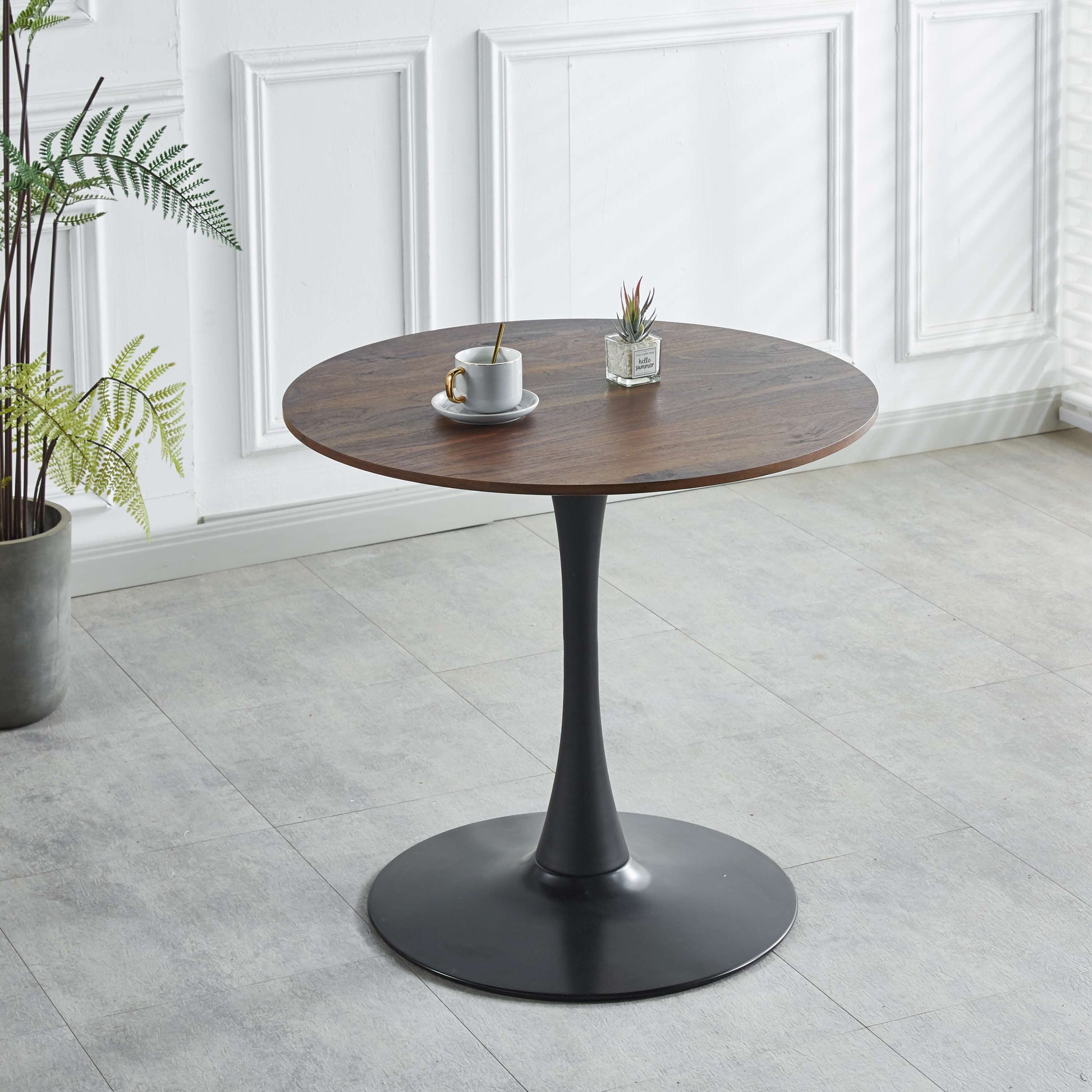 Round dark wood dining table with a black tulip base for intimate gatherings