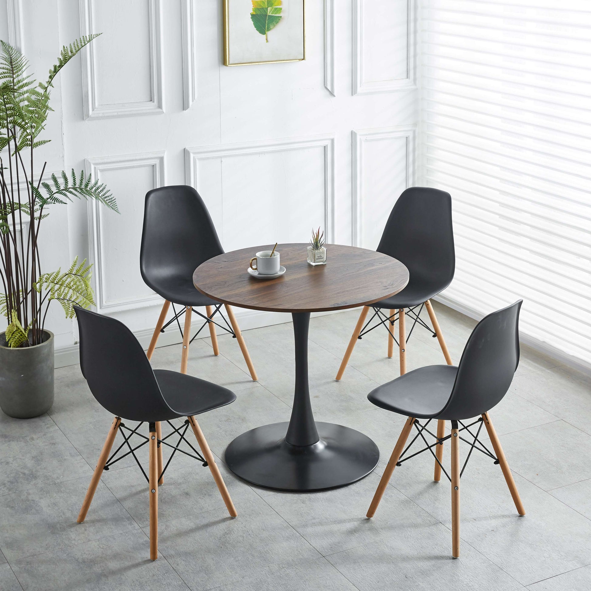 Round wood dining table with black tulip base paired with four black modern chairs
