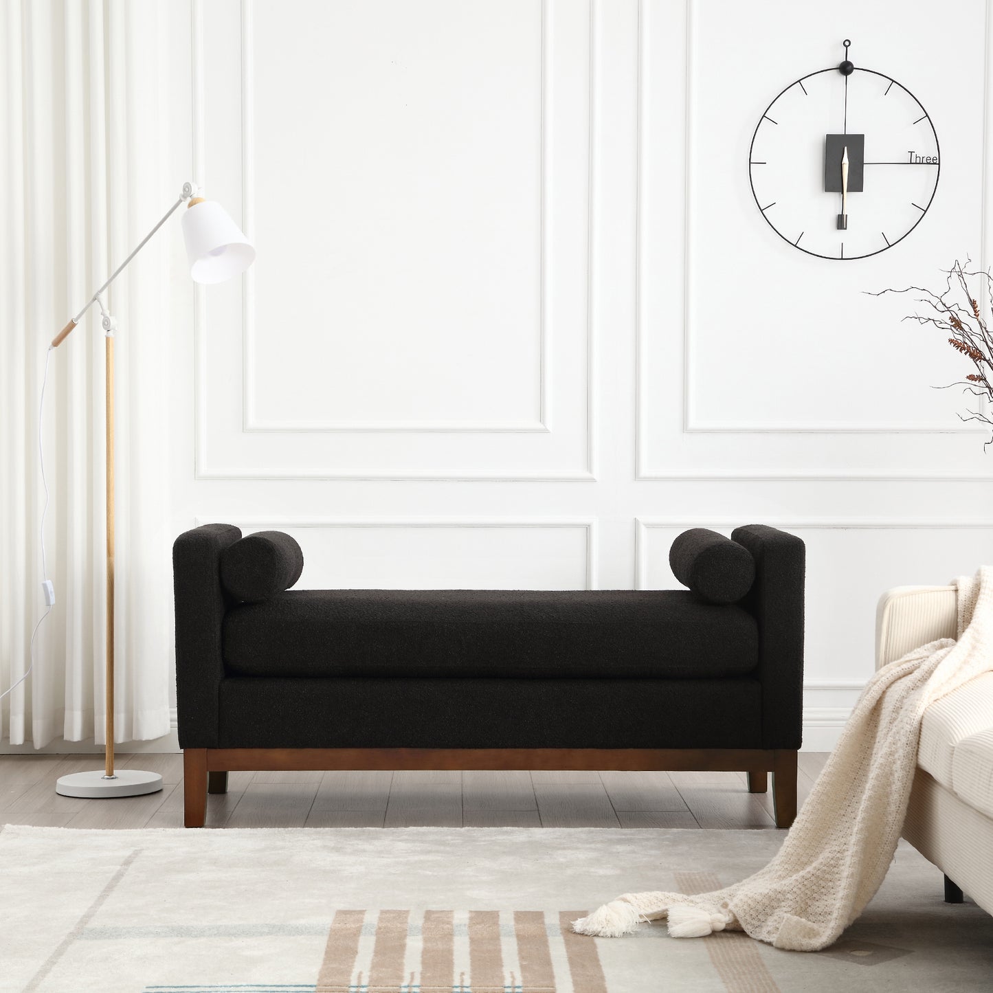 Black upholstered bench with rolled arms and wooden legs