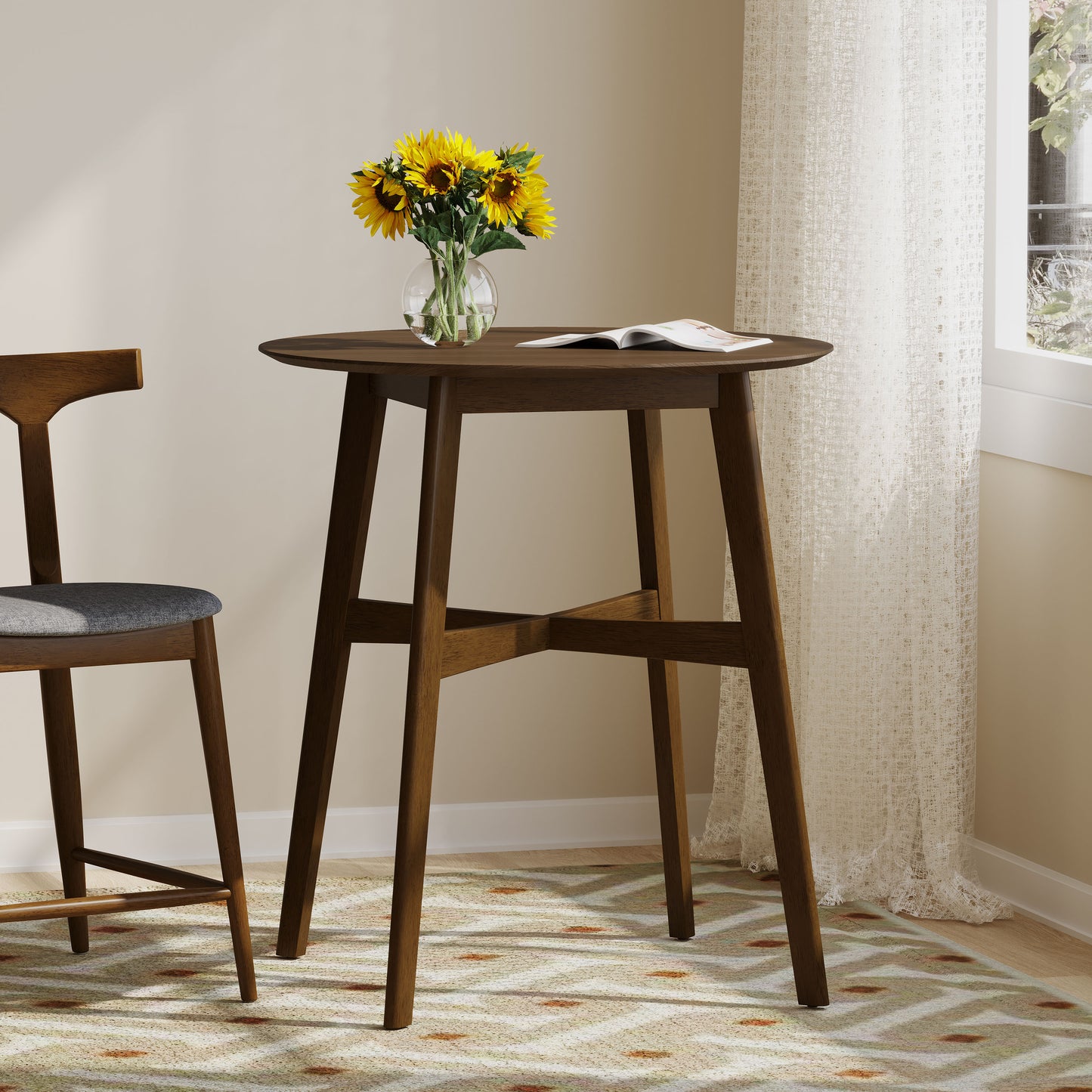 Round dark wood pub table with a vase of sunflowers and an open book
