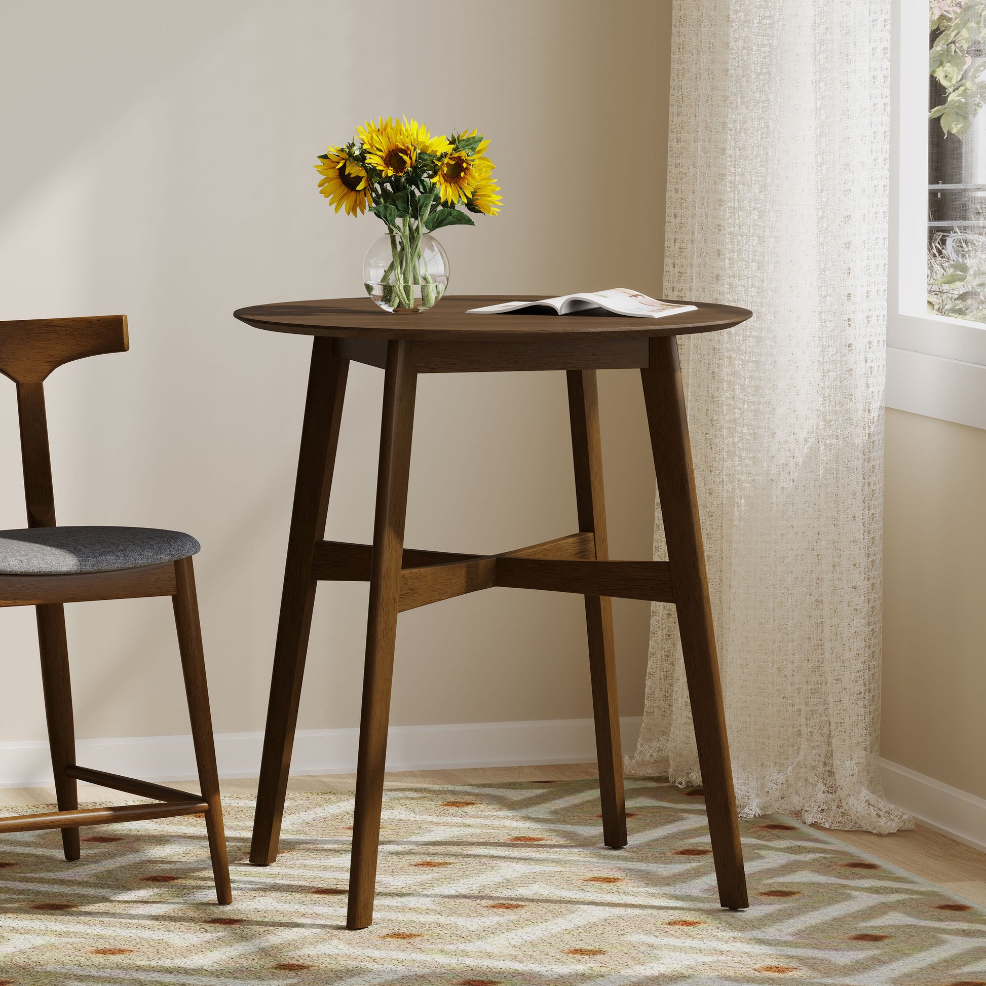 Round dark wood pub table with a vase of sunflowers and an open book
