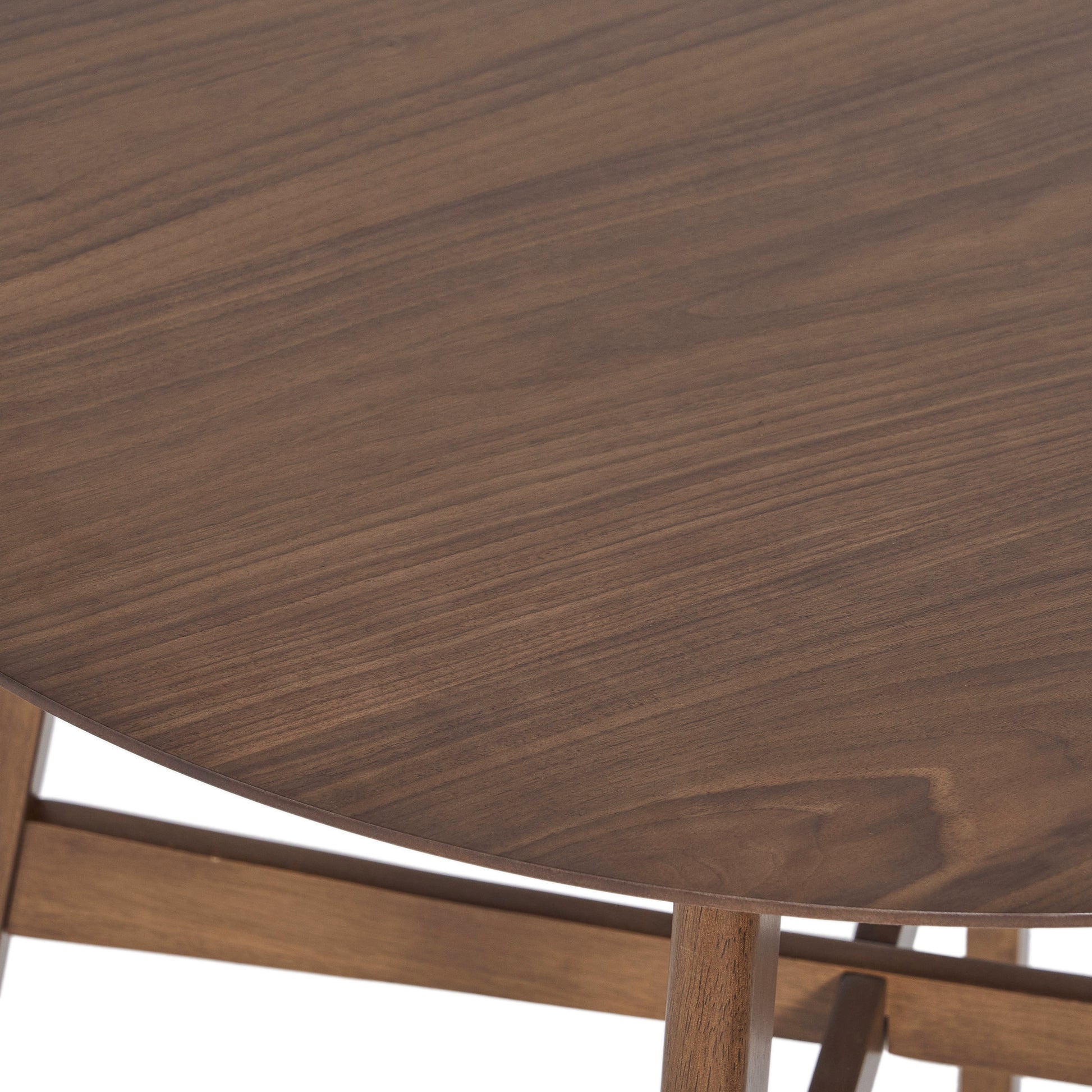 Round walnut dining table surface with visible wood grain