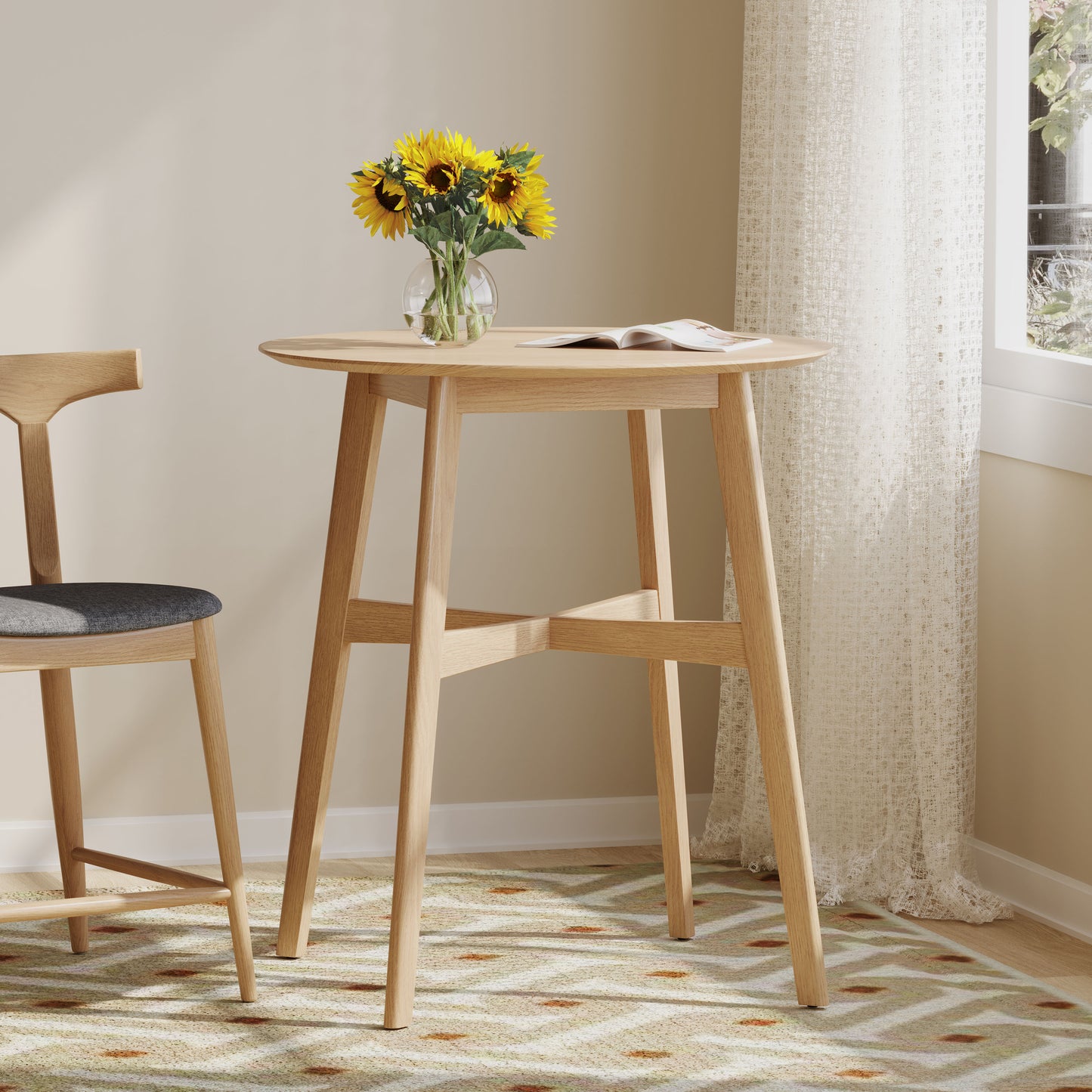 Round light oak wood pub table with a magazine and sunflowers