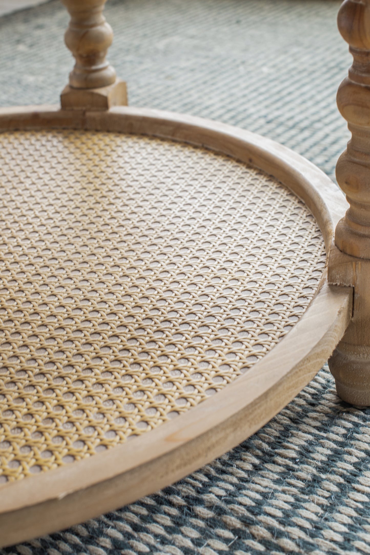 Natural woven cane tabletop detail on a light wood accent table