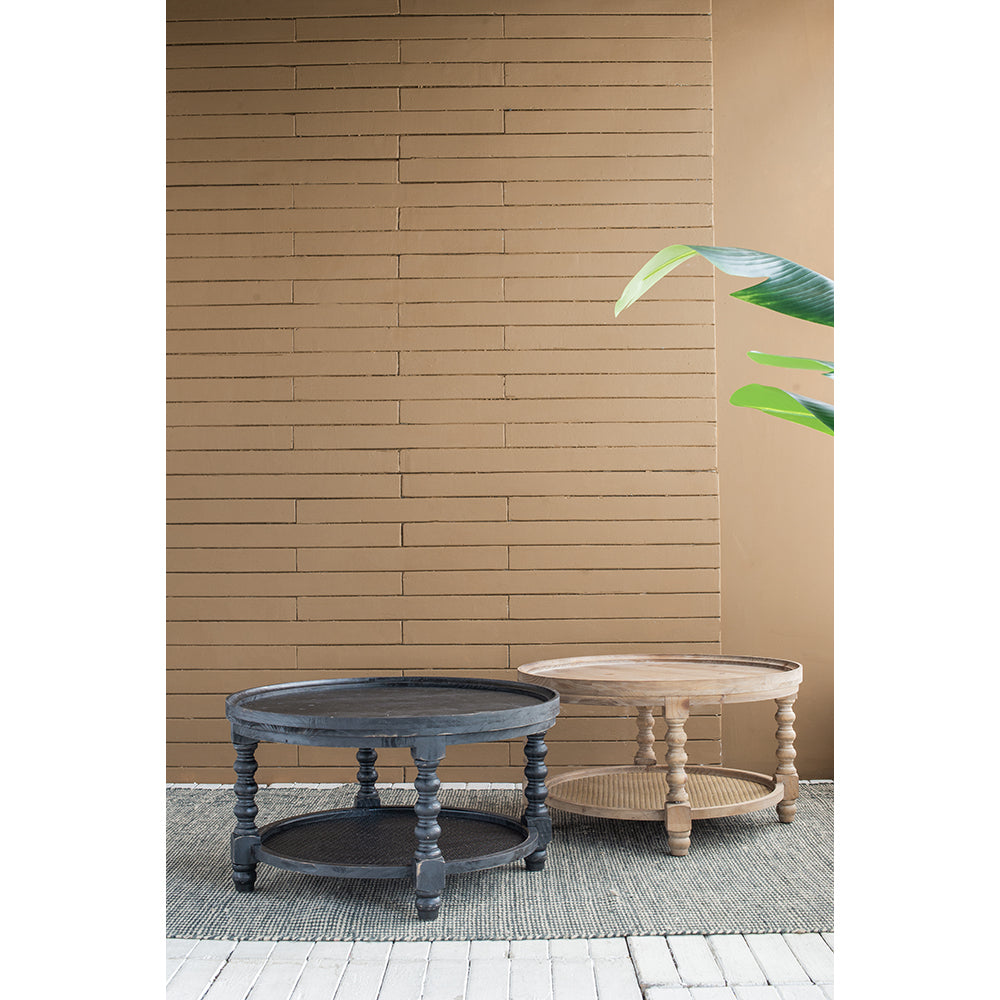 Distressed black wooden coffee table with carved legs on textured rug