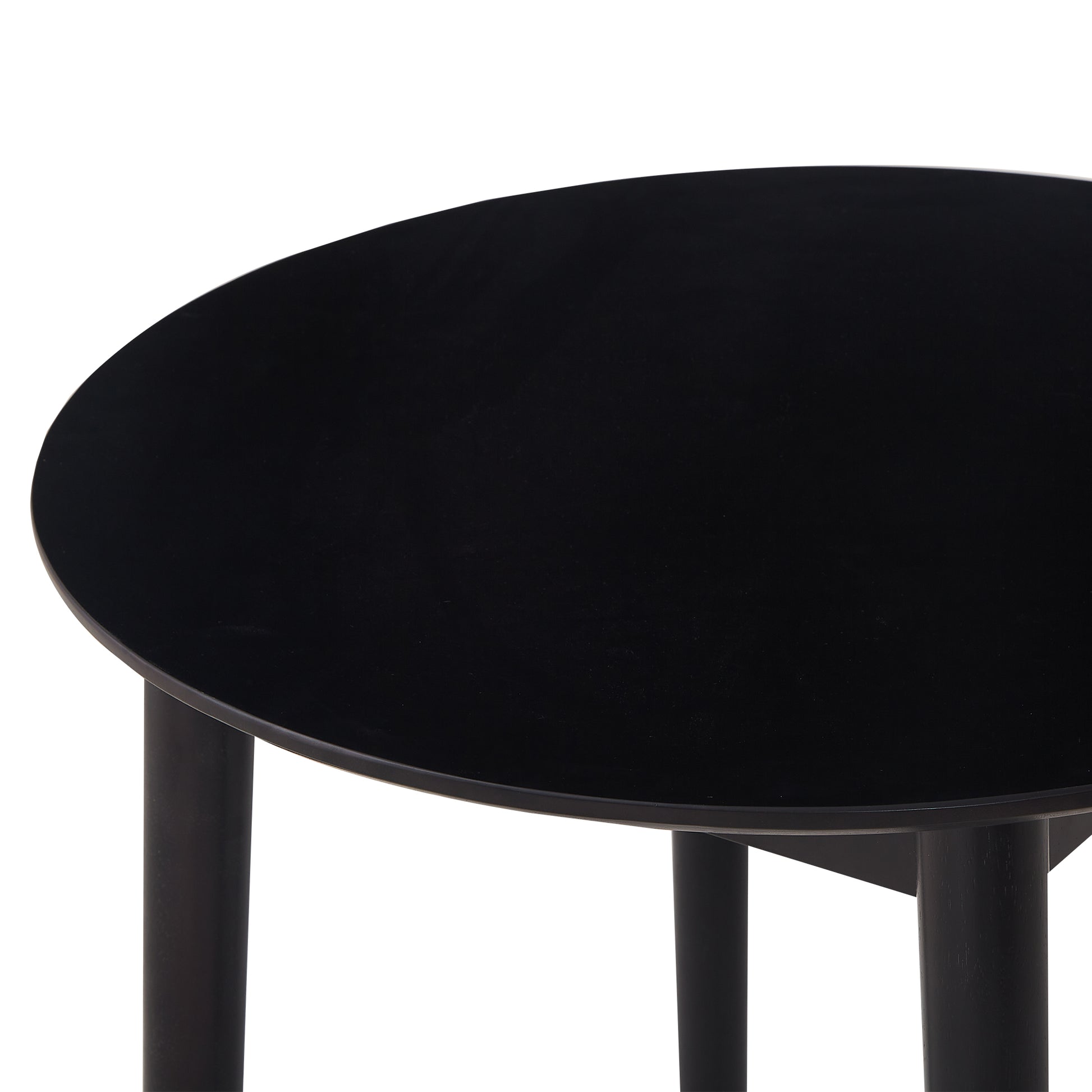 Closeup of a modern black round coffee table with minimalist wooden legs