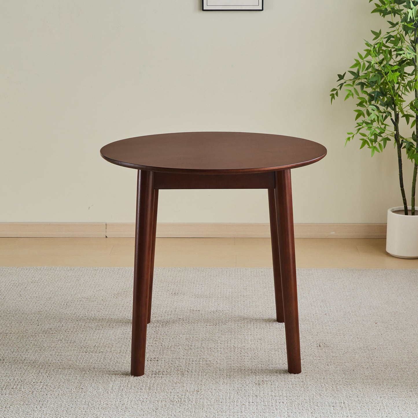 Round dark wood dining table with tapered legs