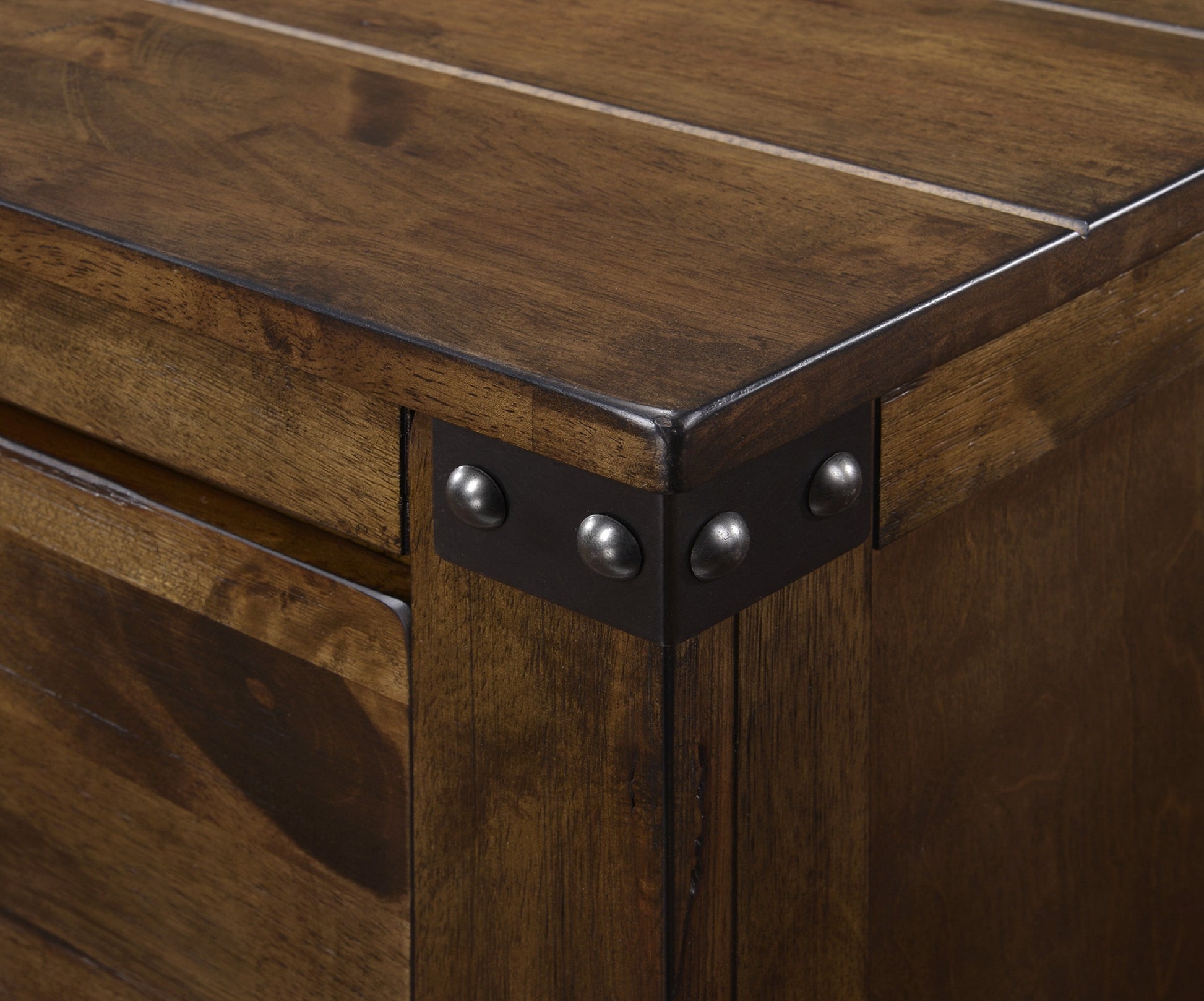 Dark wood dresser corner with metal rivets