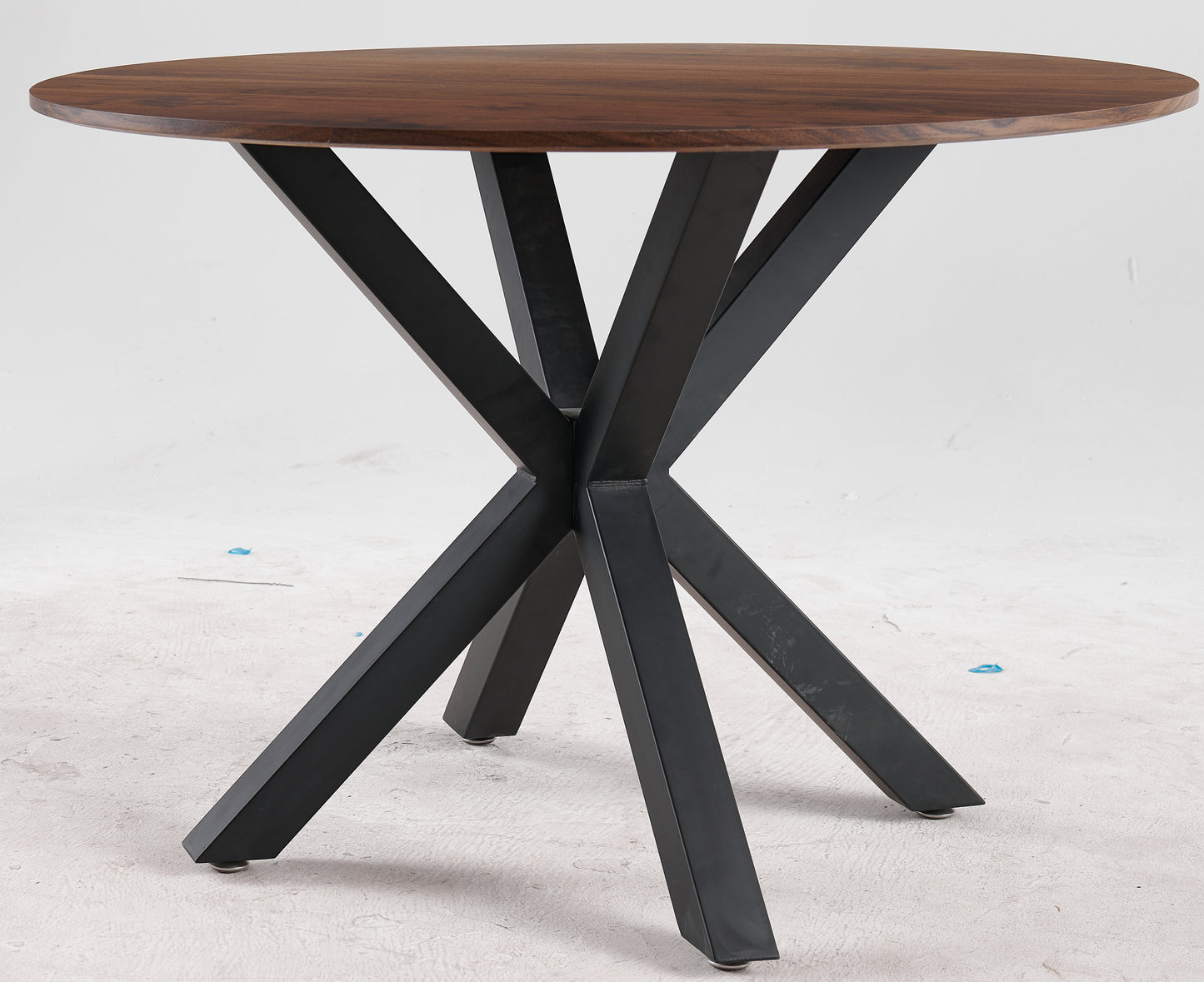 Round walnut dining table with black metal spider base