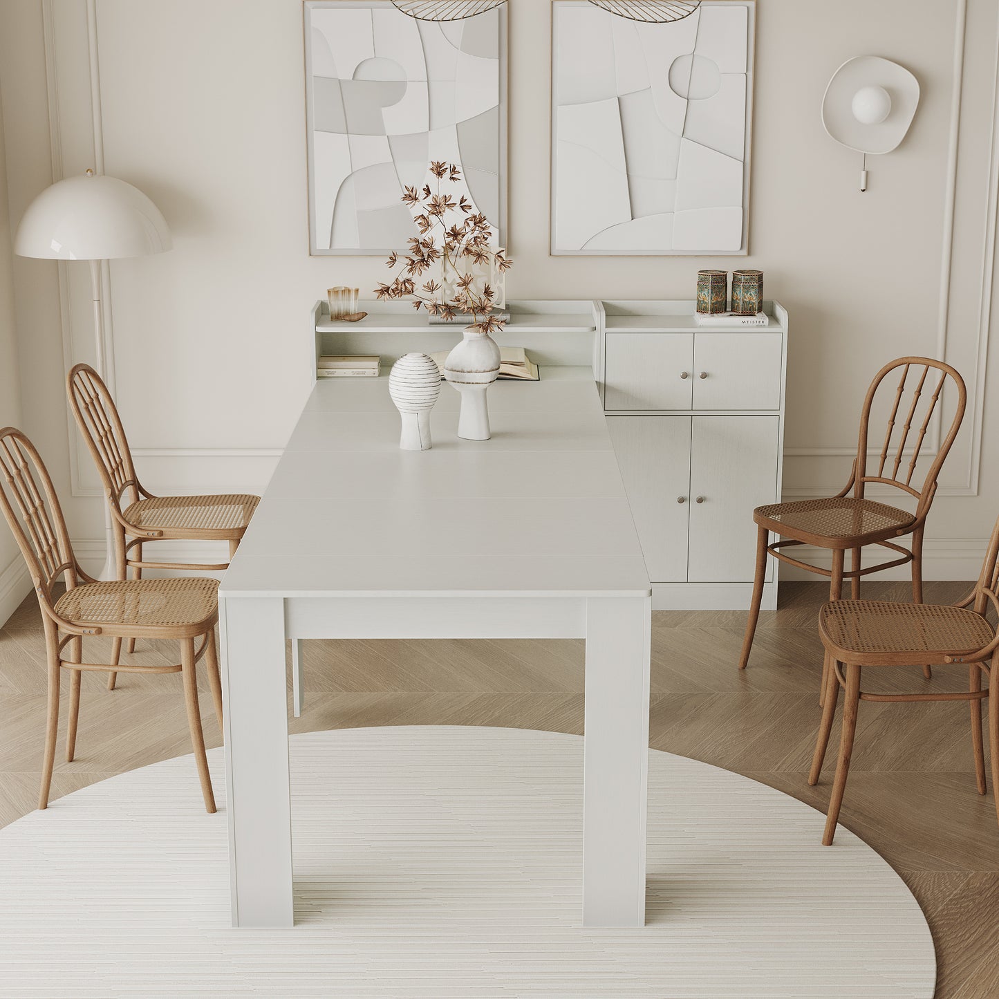 White dining table set with four canebacked chairs and modern art