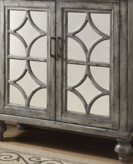 Distressed grey mirrored cabinet with geometric fretwork doors for elegant storage